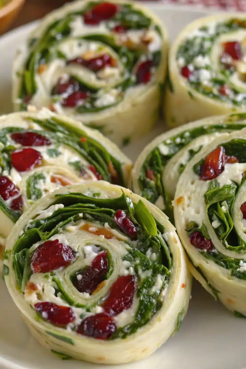 Festive cranberry feta pinwheels with a mix of sweet and tangy flavors wrapped in a creamy filling.